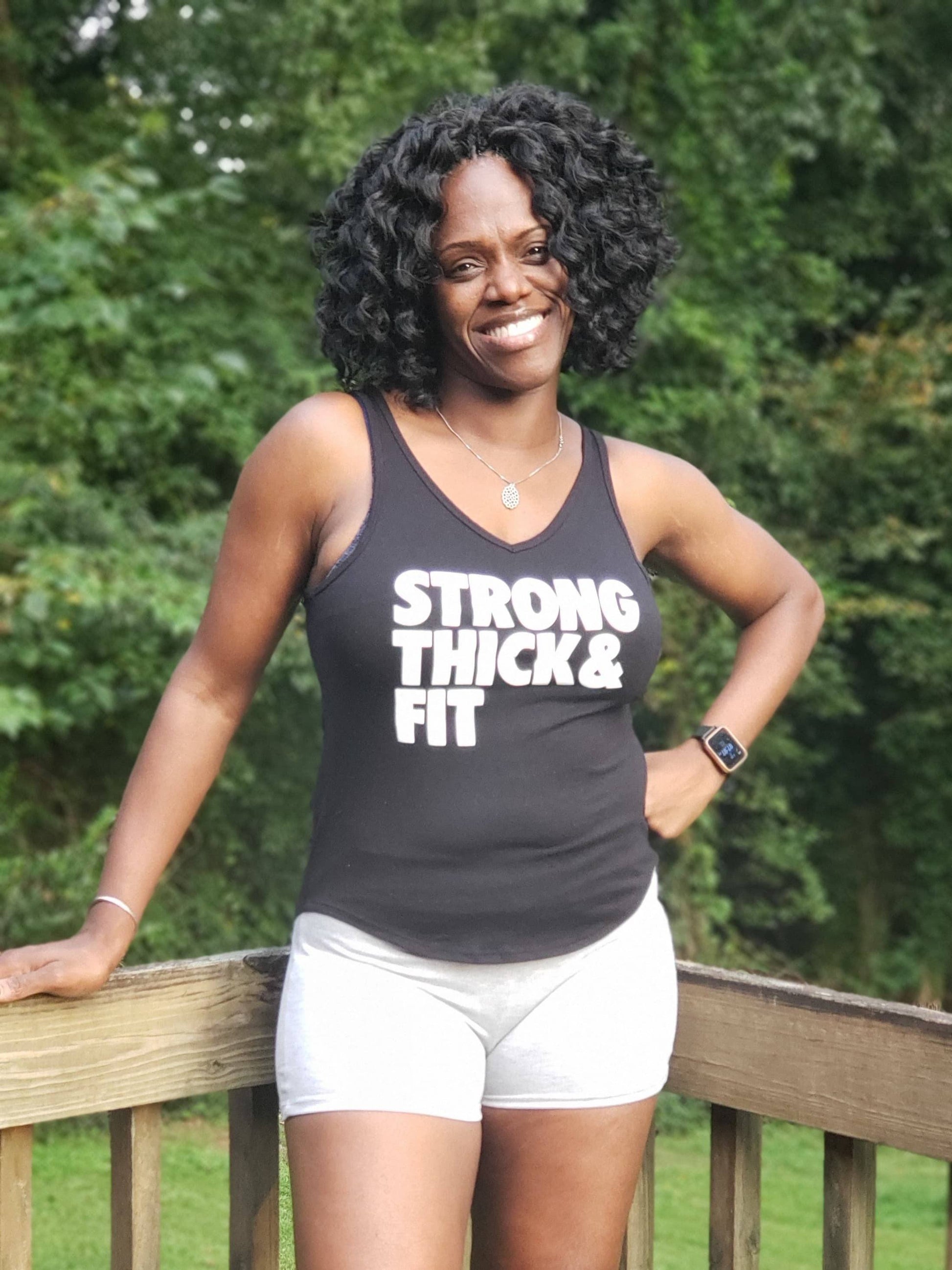 Black girl in black workout tank top that says strong thick fit 
