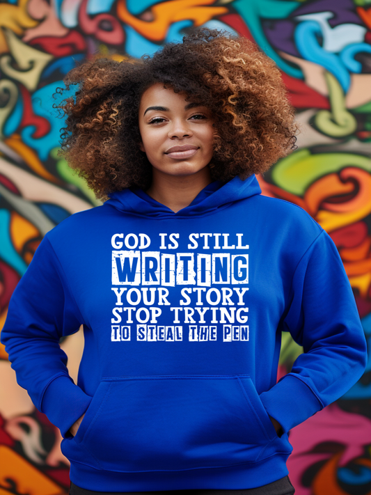 A black girl with curly hair wearing a royal blue hoodie that says God is still writing your story.
