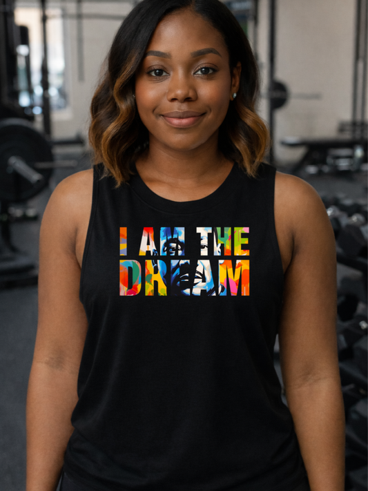 Black woman  wearing a black tank top with 'I AM THE DREAM' text in colorful letters in a gym setting.