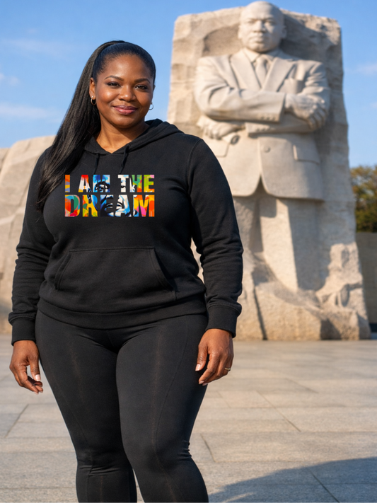 Black woman wearing a black hoodie that says I am the dream standing in front of the MLK monument