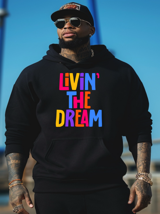 A Black man wearing a black hoodie with 'LIVIN' THE DREAM' written in colorful letters on the front.