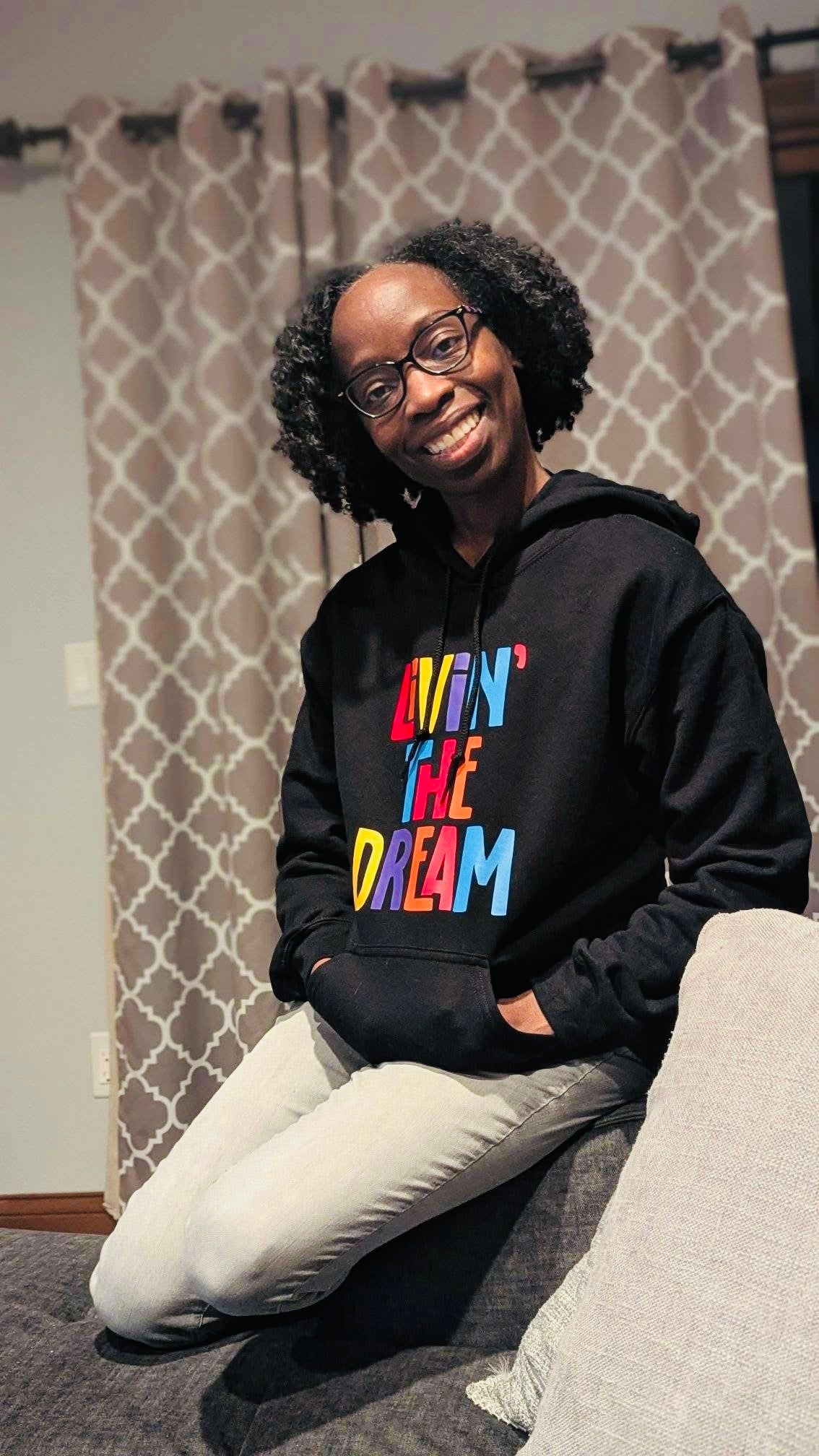 A black girl wearing a black hoodie that says Livin the dream 