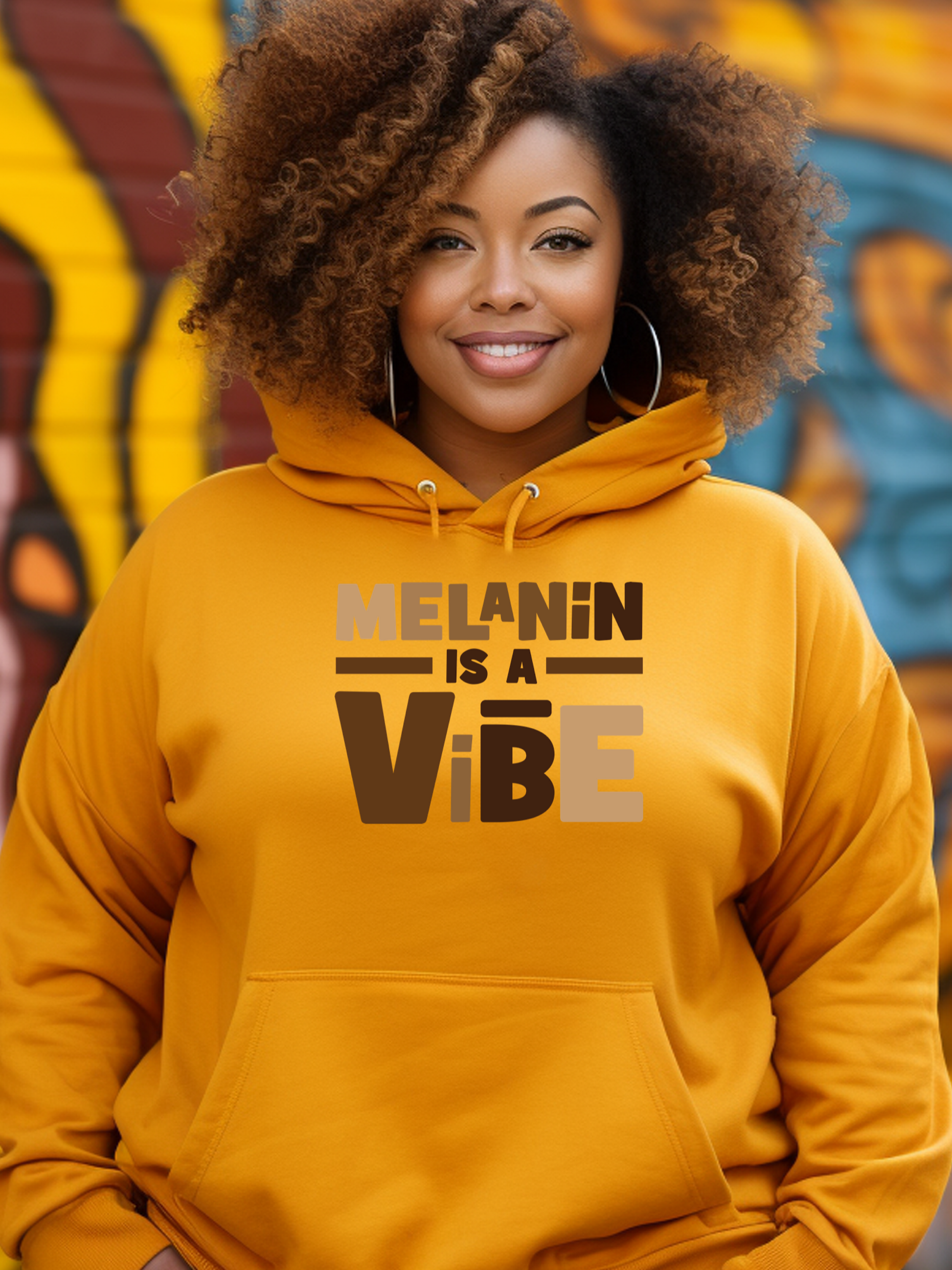 Person wearing a yellow hoodie with 'Melanin is a Vibe' text, standing in front of a colorful mural.