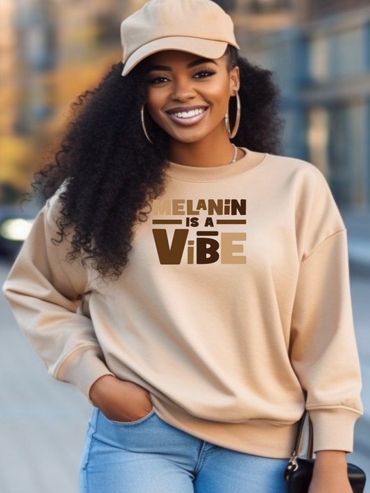 Black girl in a city scene wearing a Melanin is a vibe tan sweatshirt 