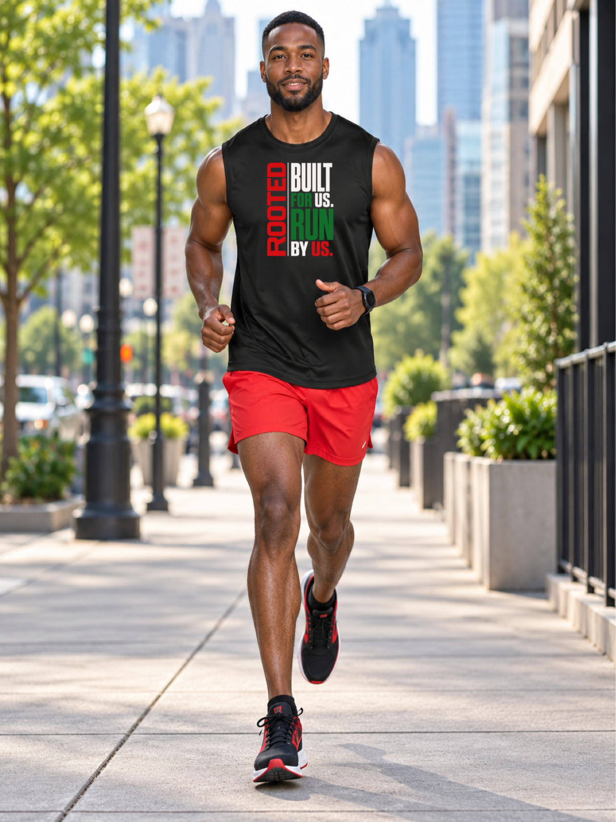 A Black man jogging on a city sidewalk wearing a black sleeveless athletic tank top with the text 'ROOTED BUILT US. RUN BY US.