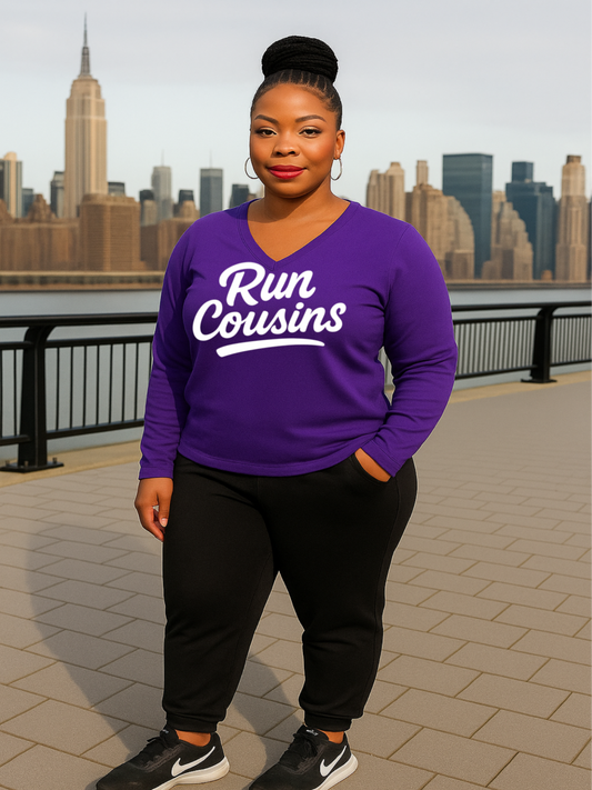A woman wearing a purple long-sleeve shirt with 'Run Cousins' text, standing in front of a city skyline.