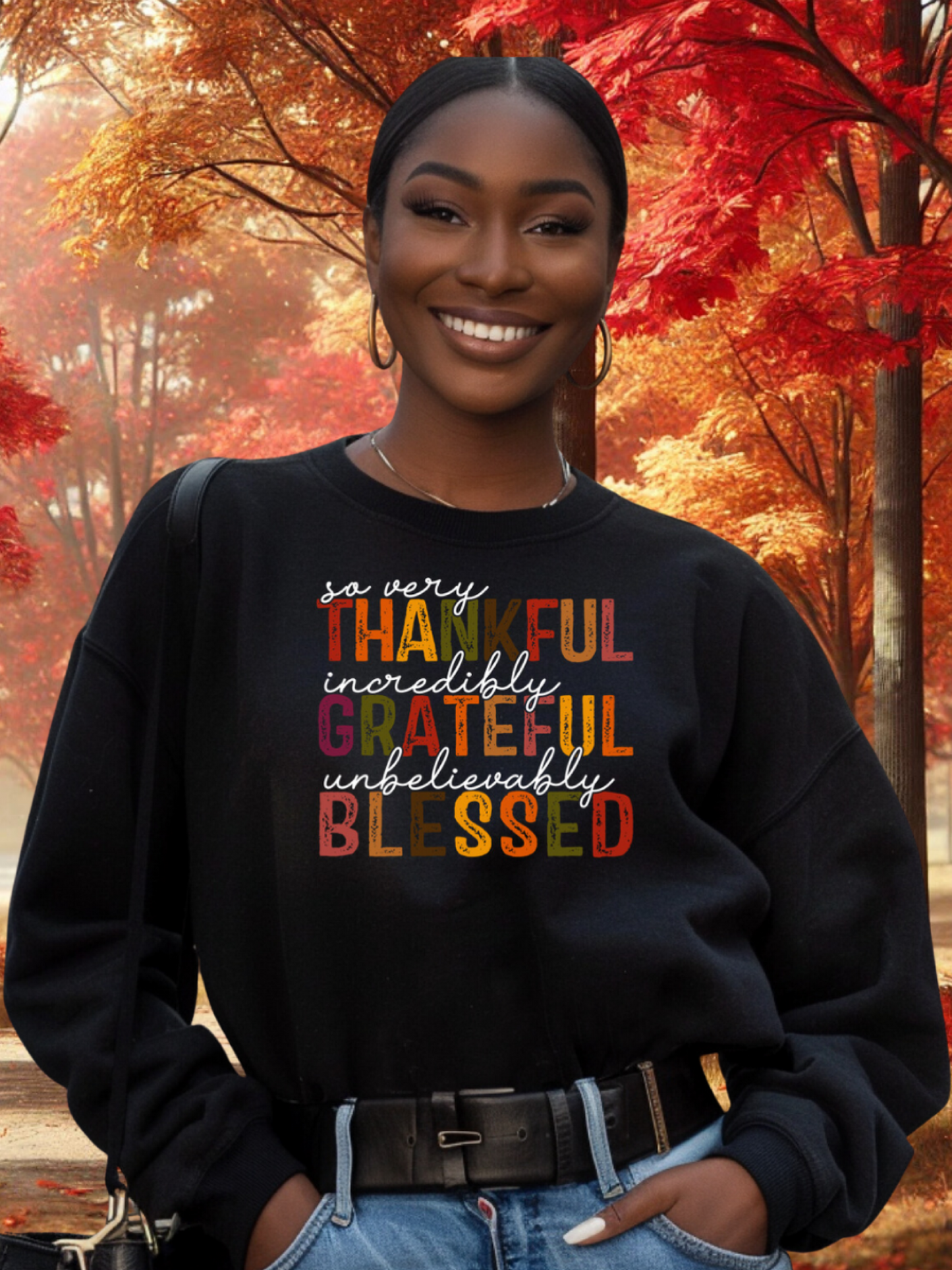 Woman wearing a black sweatshirt with colorful text in an autumn setting