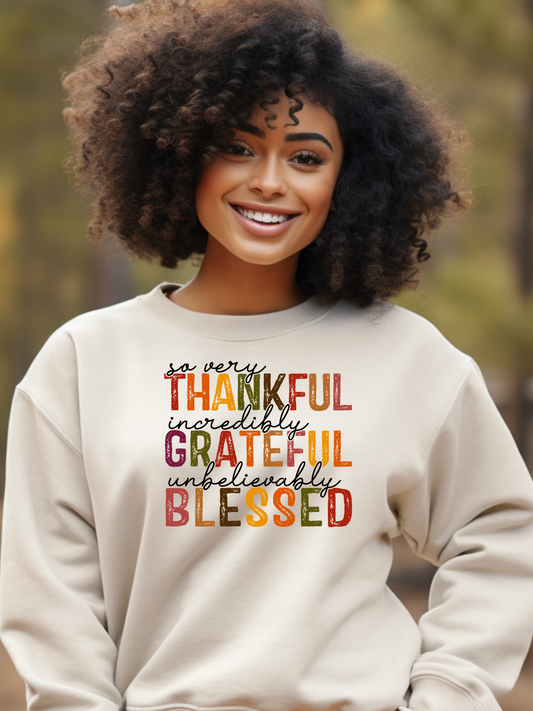A black girl wearing a tan sweatshirt with the Thankful Grateful Blessed design