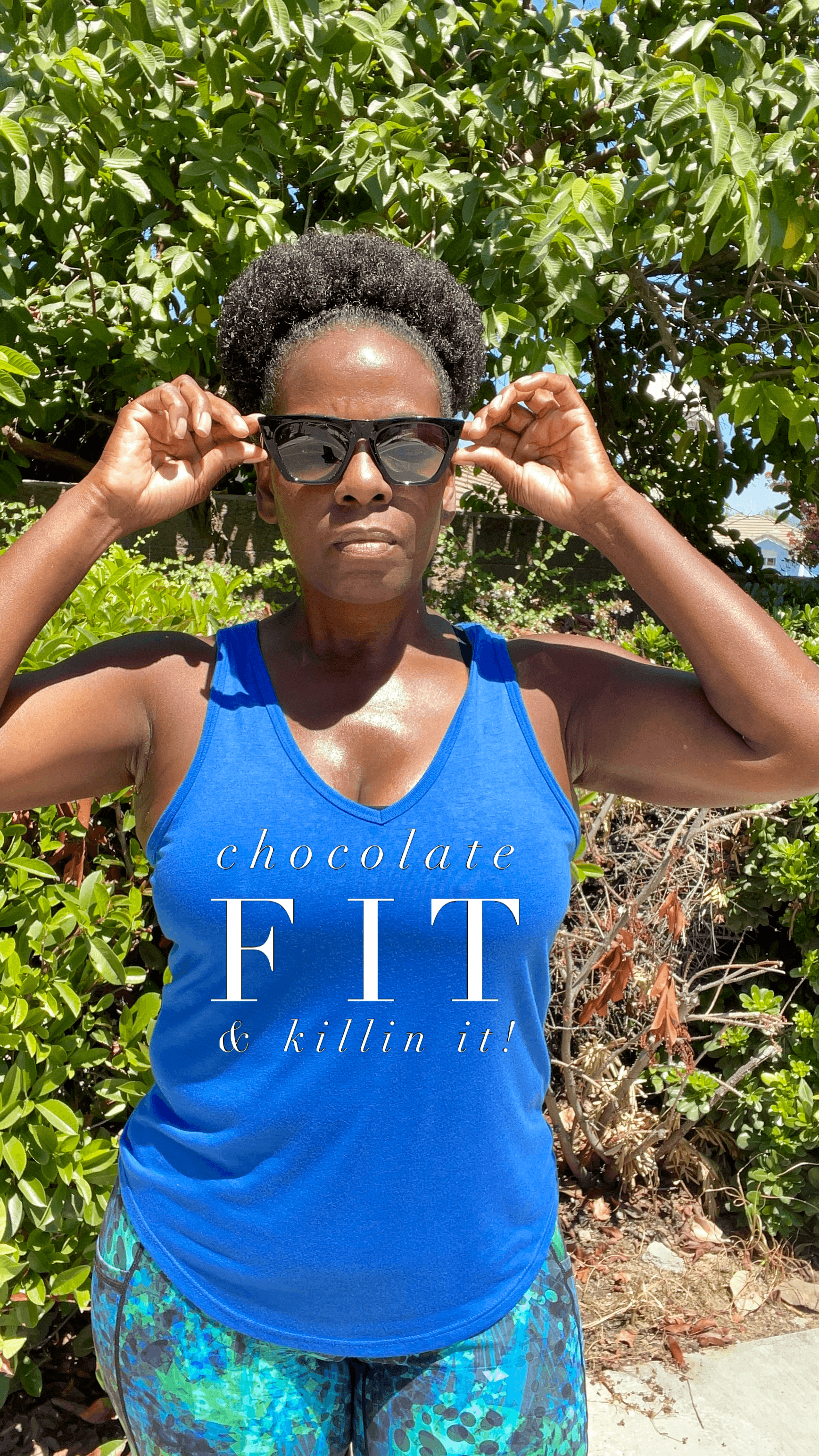 Black Girl wearing a royal blue running tank top. The tank says Chocolate Fit & Killin it 