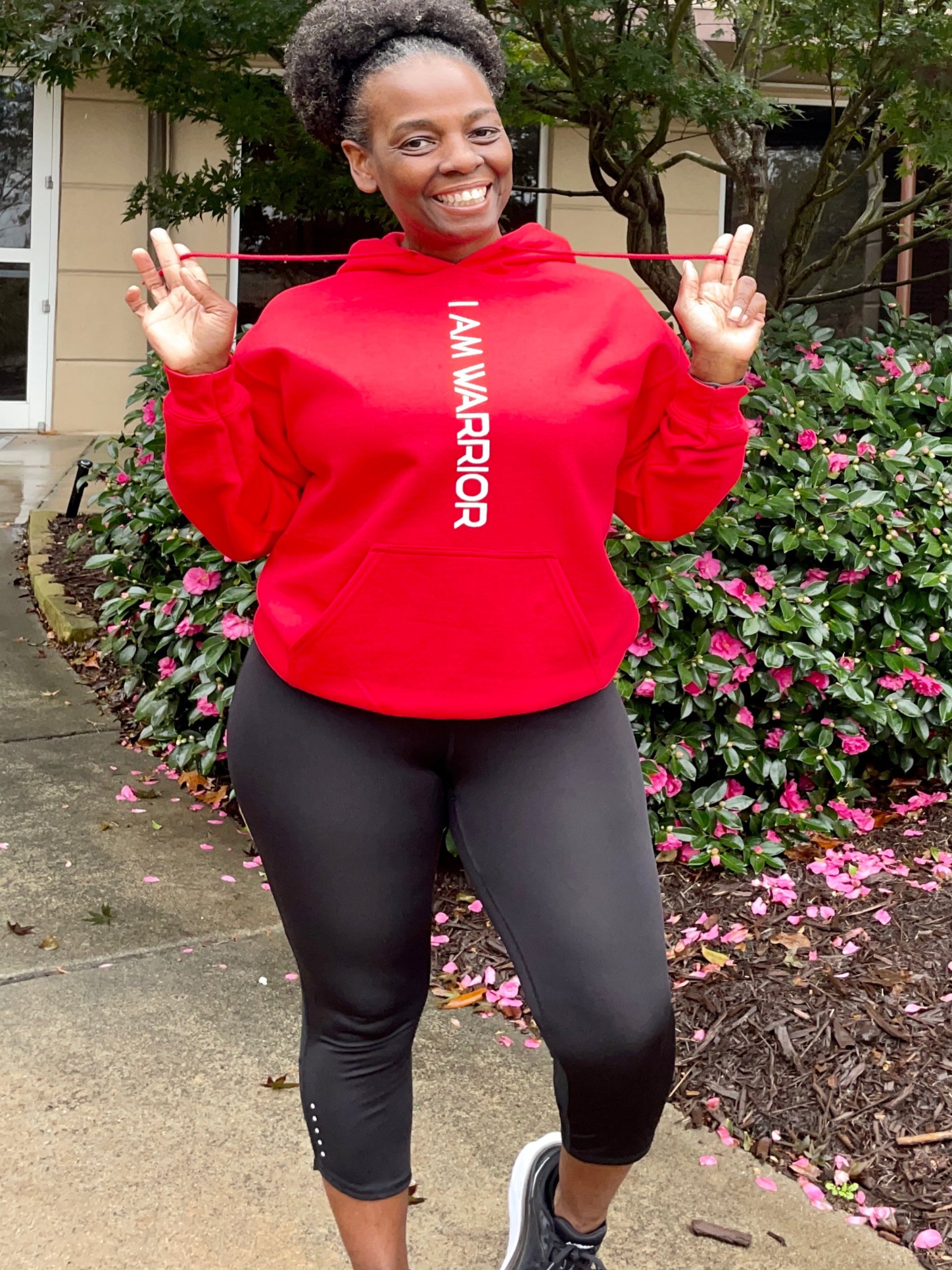 Girl wearing a red hoodie that says I Am Warrior