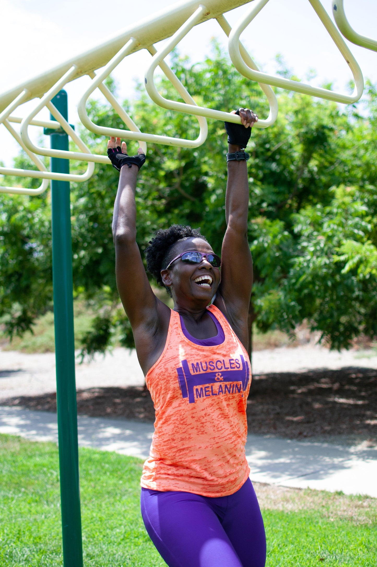 Black Girl wearing Orange Muscles & Melanin workout tank Top while working out 