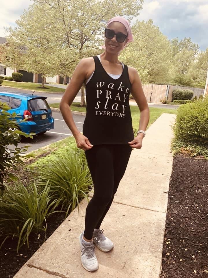 Girl showing off her new fitness tank top that says Wake Pray Slay Everyday