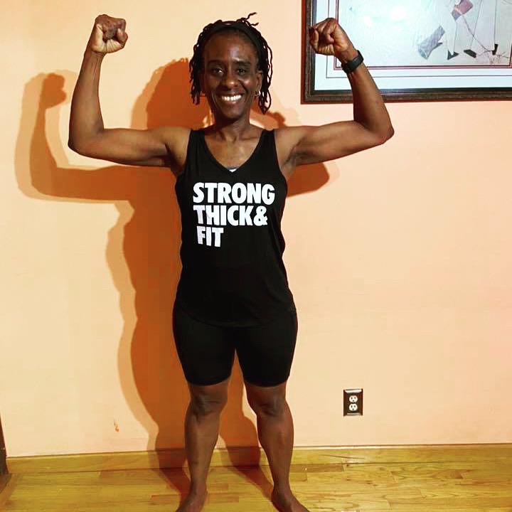 Black Girl with muscles wearing a black Strong thick Fit workout tank top 