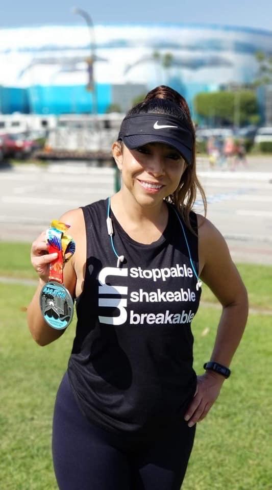 Girl with race medal wearing the Un Stoppable - Shakable - Breakable Muscle Tank Muscle Tank 