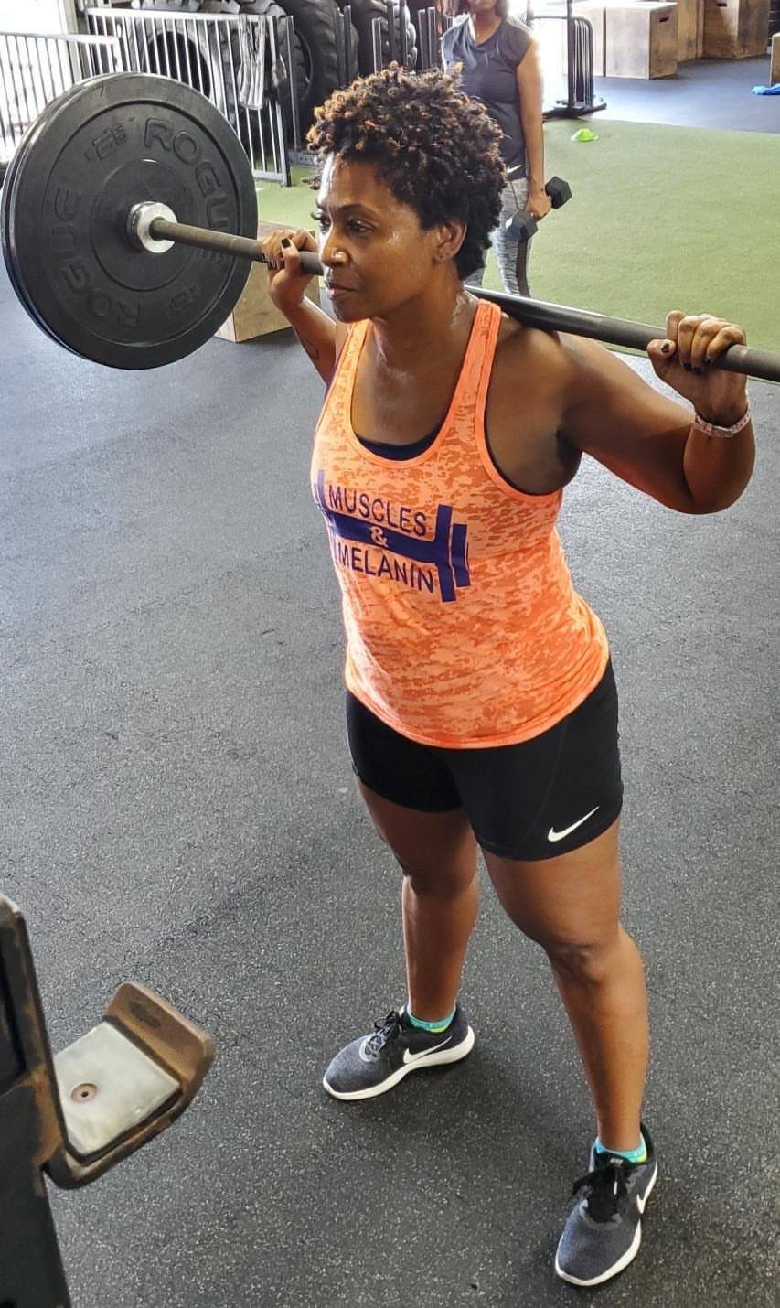 Black Girl squatting wearing a Muscles & Melanin Tank Top 
